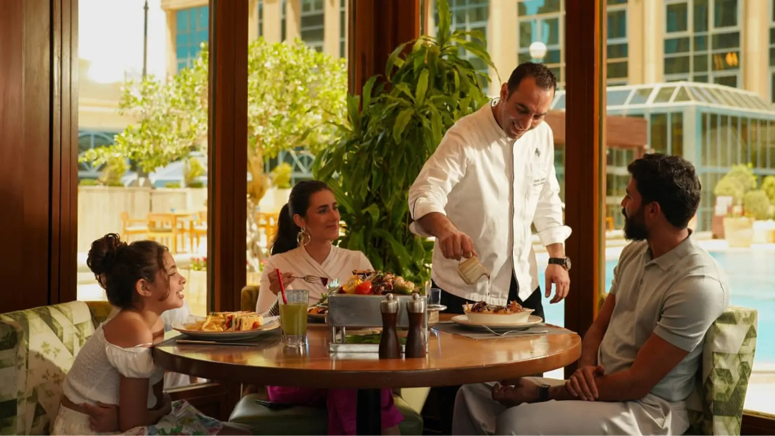 Family served tableside during poolside dining at Four Seasons Hotel Cairo at The First Residence
