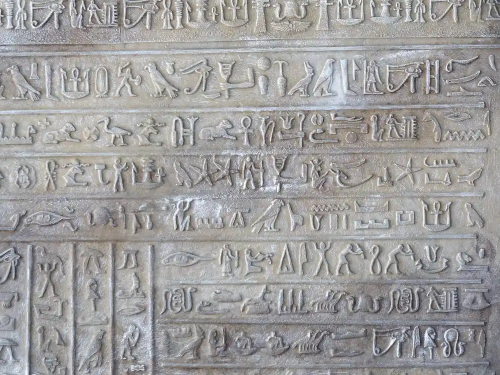 Hieroglyphs, a temple and desert sand at Theban hills in Luxor, Egypt