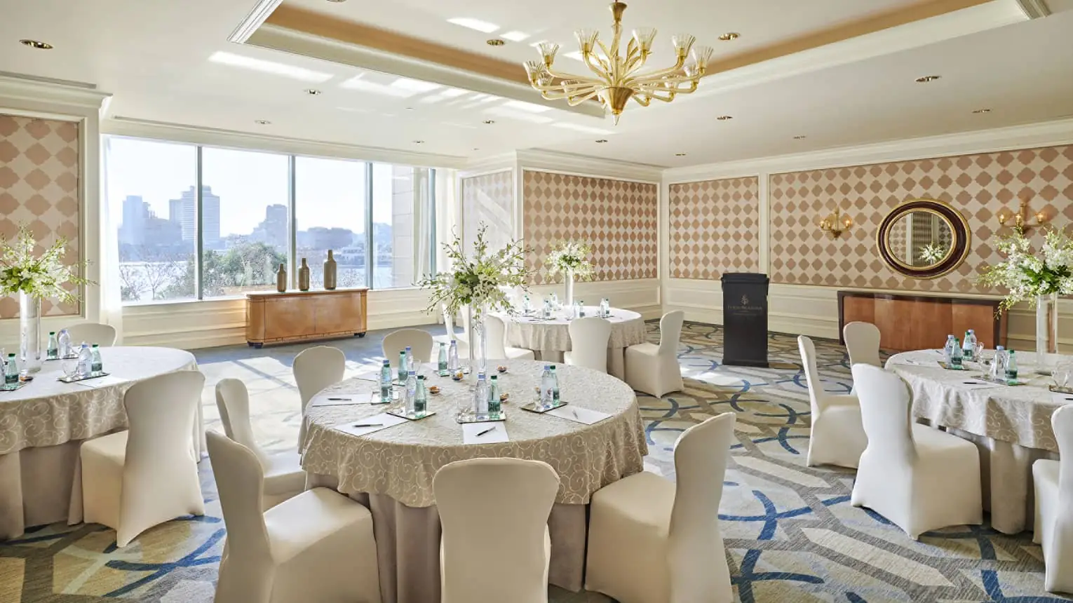 Banquet room at Four Seasons Hotel Cairo with round tables and Cairo skyline views