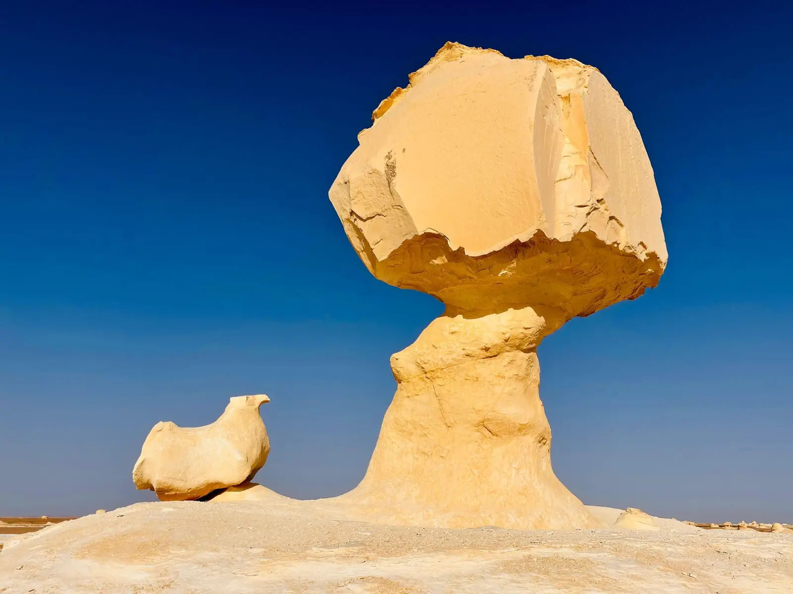White desert sand and stone at White Desert in Farafra, Egypt under a blue sky
