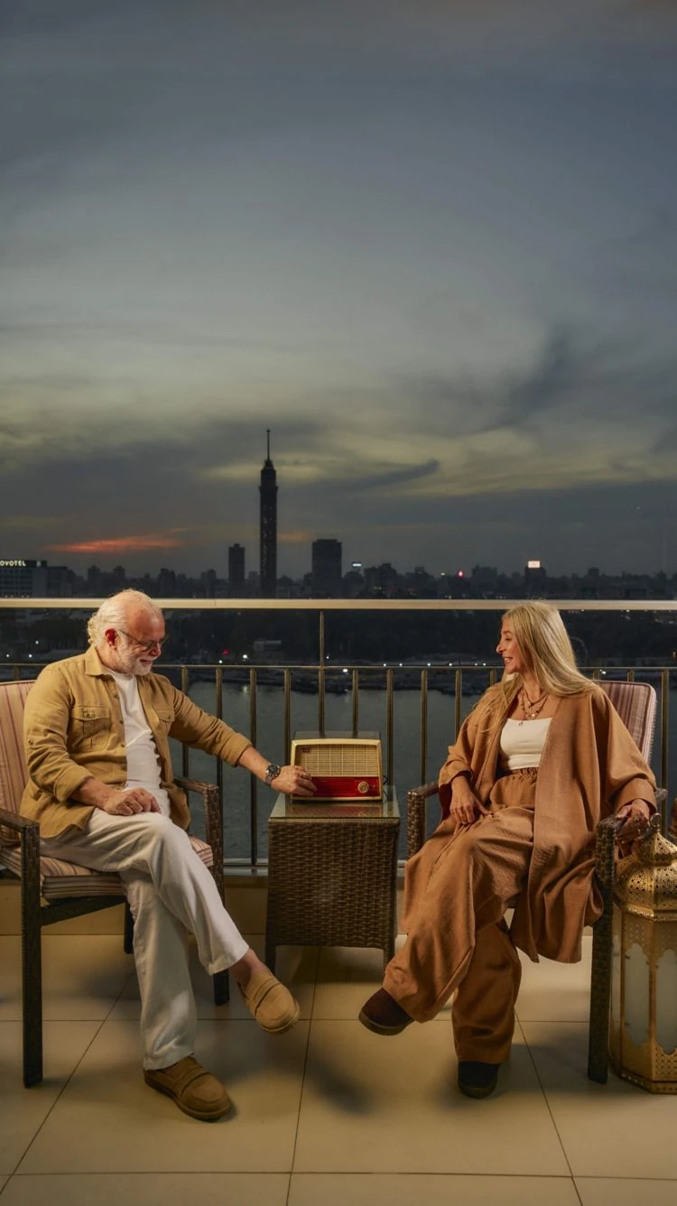 Couple relaxing on a balcony at The Nile Ritz-Carlton Cairo with Cairo Tower views at dusk