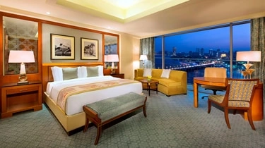 Guest room at The Nile Ritz-Carlton Cairo with an evening Nile River view