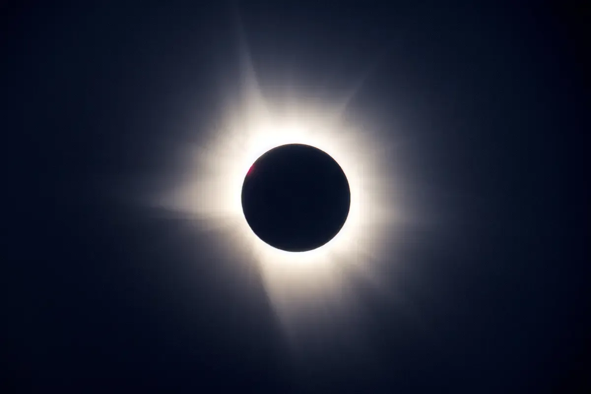 Total solar eclipse with the corona glowing around the black disc of the moon