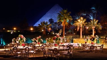Outdoor evening event setup at Marriott Mena House Cairo with the Great Pyramid illuminated
