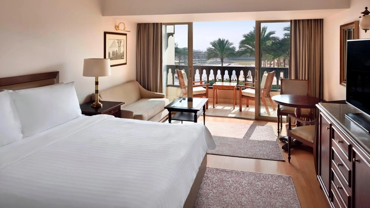 Guest room at Mena House Hotel Cairo with a private balcony overlooking palm trees