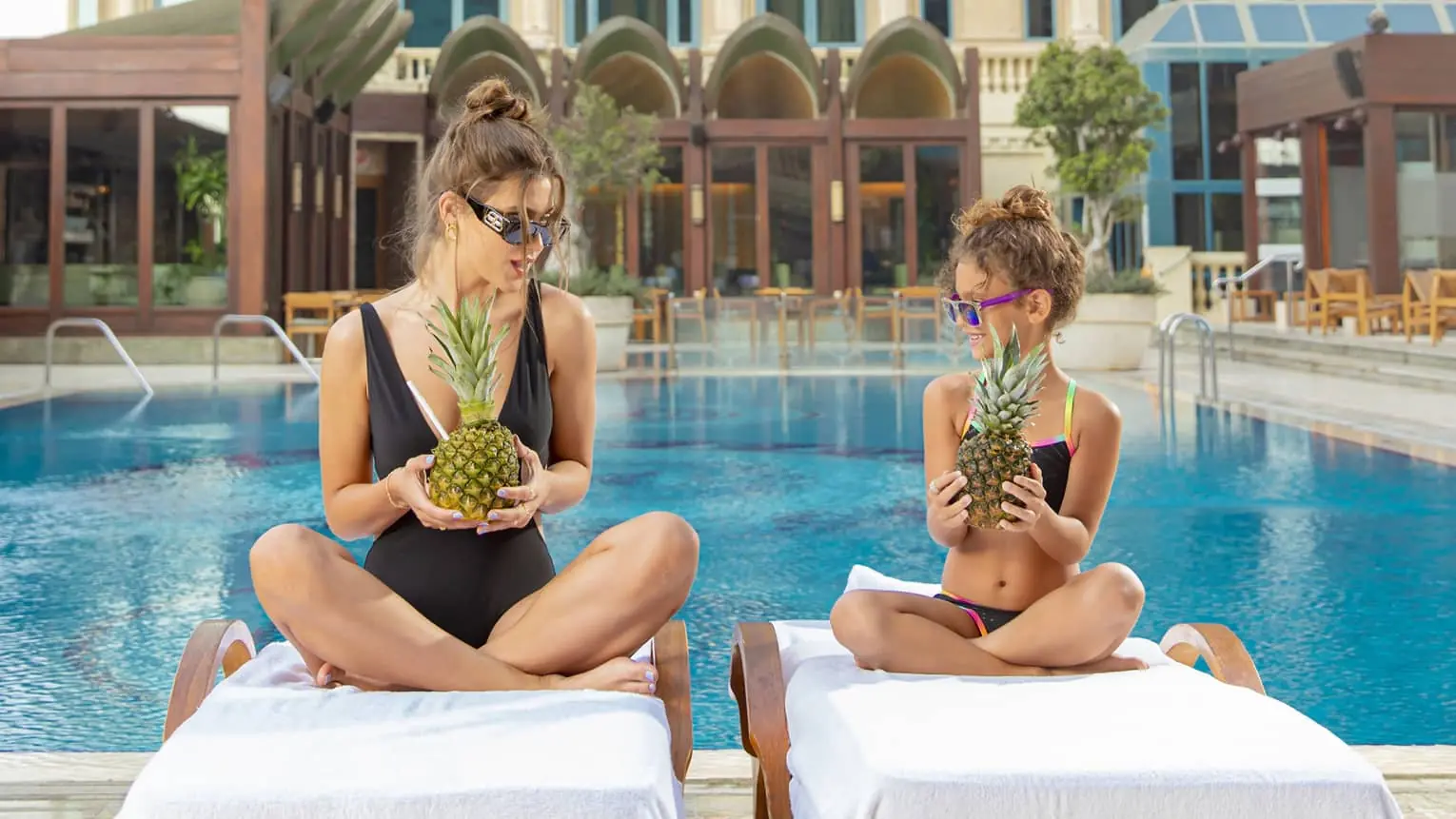 Mother and daughter relaxing poolside at Four Seasons Hotel Cairo at The First Residence