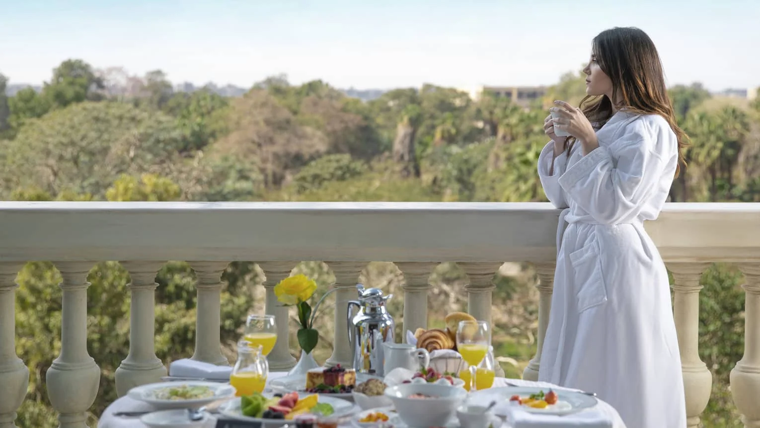 Guest enjoying balcony breakfast with garden views at Four Seasons Hotel Cairo at The First Residence