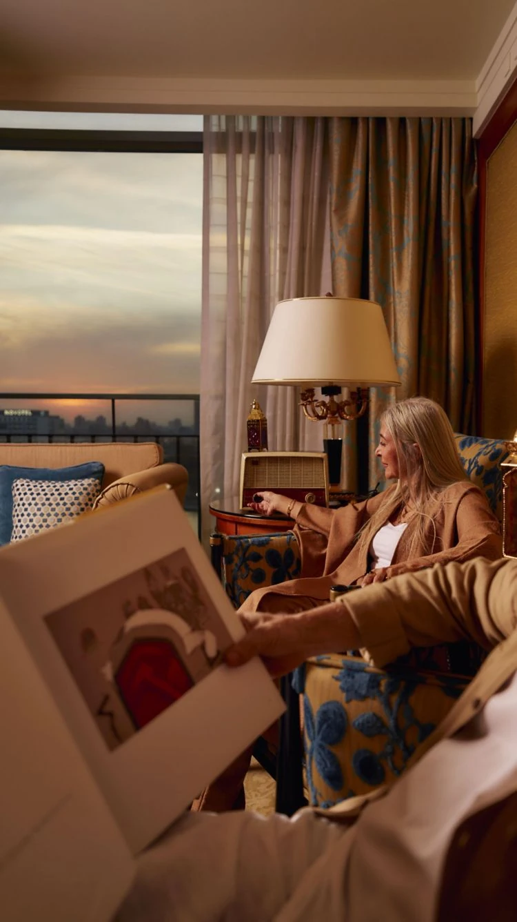 Couple unwinding in a suite living room at The Nile Ritz-Carlton Cairo at sunset